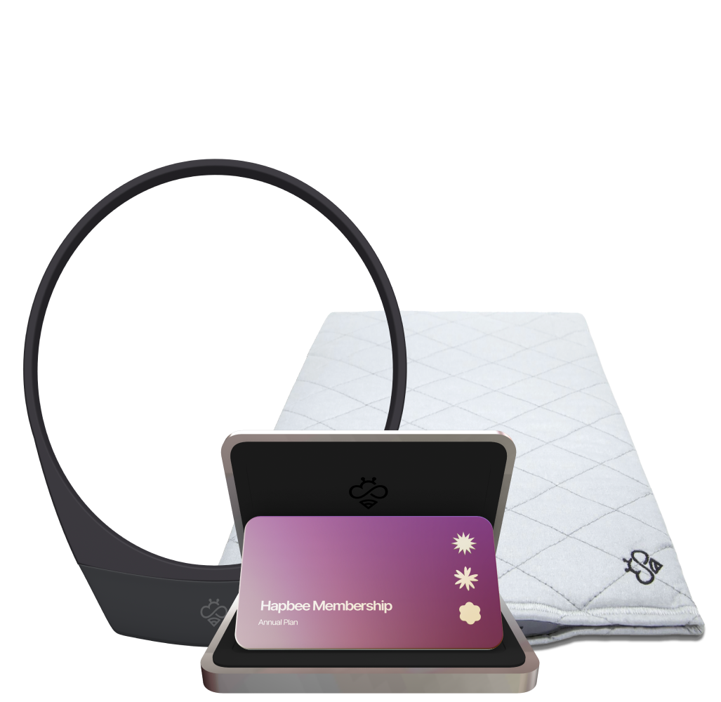 A collection of Hapbee products including a wearable device, a mat, and a membership card, indicating a wellness and fitness focus.